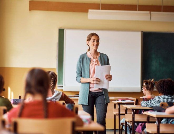 happy elementary school teacher giving lecture to 2022 11 16 14 47 56 utc 1024x683