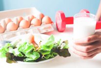 1790584055 fresh salad with egg hand holding glass milk healthy menu with red dumbbells healthy life